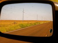 Road reflected in side-view mirror
