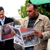 Tunisian men read the newspaper on Janaury 18, 2011 at the Kasbah in Tunis.