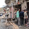 Iraqis inspect the damage after a wave of attacks in Baghdad killed at least 57 people on December 22, 2011. The apparently coordinated blasts were the first major sign of violence since US withdrew.