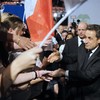 France's incumbent president and Union for a Popular Movement (UMP) party candidate for the French 2012 presidential election Nicolas Sarkozy (R) shakes hands with supporters after delivering a speech