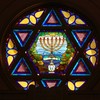 stained glass window in the shape of the Star of David with menorah