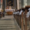 pews of a church lined with white bows for a wedding