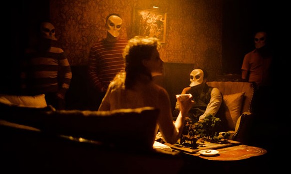 Masked audience members look at cast member Tori Sparks who plays Lady MacBeth in some of the productions.