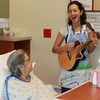 Danielle DeCosmo, an artist in residence at Shands, plays for a patient.