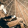 Nikola Tesla in front of the spiral coil of his high-frequency transformer in New York.