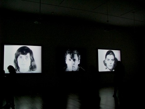 An installation view of Warhol's Screen Tests at MoMA, featuring (from left to right): Susan Sontag, Dennis Hopper and Kathe Dees. Sontag doesn't break; Hopper is a ham.