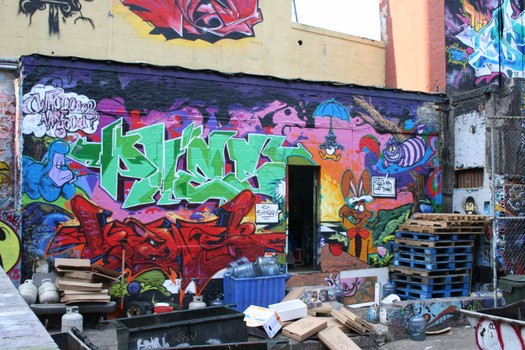 A piece with the characters from Alice in Wonderland spans the length of one of the building's walls. 
