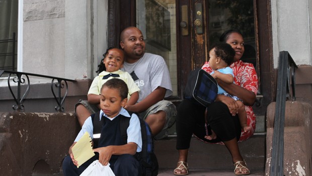 Tamicka and Shadreck Chiripanyanga wait on the stoop for the bus with their kids Jayda, Jalen and baby Jeremiah.