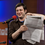 Eugene Mirman holds the full-page attack ad against Time Warner Cable he placed in The Greenpoint Gazette.