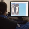 A TSA officer demonstrates what the images form the Advanced Imaging Technology unit look like at John F. Kennedy International Airport's Terminal 8 passenger security checkpoint on October 22, 2010