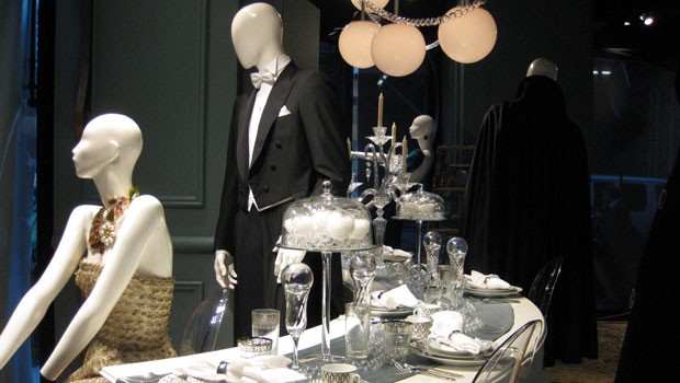 The Saks windows open with a cocktail party at a giant table setting.