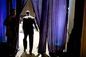 Barack Obama emerges from behind a curtain, Jan. 8, 2009.