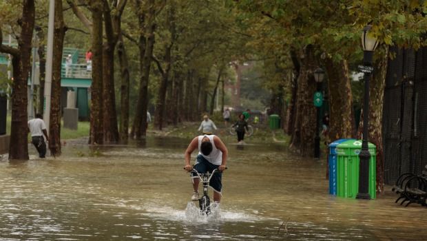 A young man rides his bicycle through flood waters along the East River Bikeway after Hurricane Irene dumped more than six inches of rain August 28, 2011 in New York City. 