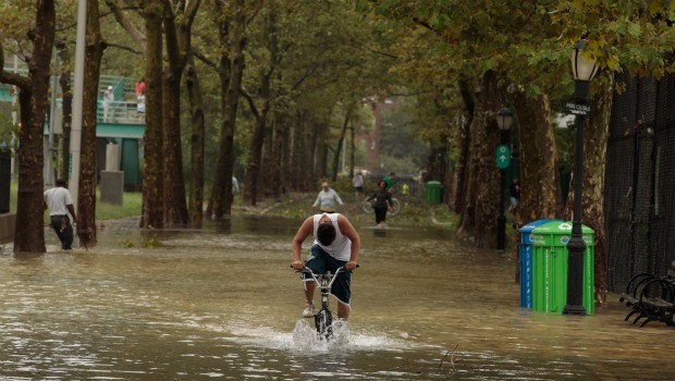 A young man rides his bicycle through flood waters along the East River Bikeway after Hurricane Irene dumped more than six inches of rain August 28, 2011 in New York City. 