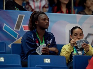 Claressa Shields and Alex Love play cards in the crowd waiting for their teammates to compete.