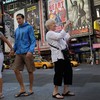 Claire Chitao (R) on vacation from Wisconsin snaps a photograph in Times Square August 29, 2011 in New York City. One day after Irene hit New York the city continues to get back to normal.