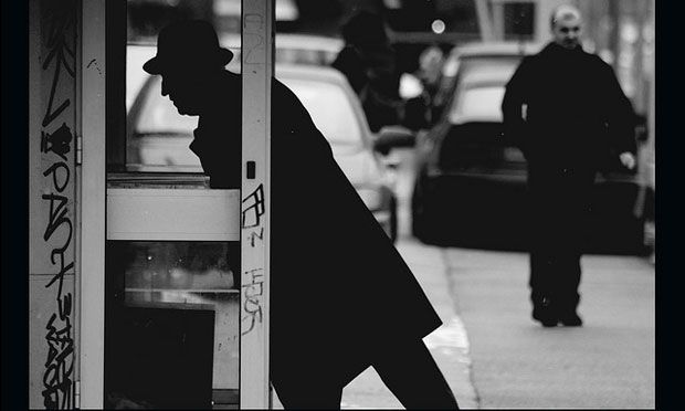 Man ducking into phone booth