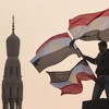 A youth waves Egyptian flags from a lamp post in Tahrir Square on February 1, 2011 in Cairo, Egypt.