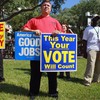 Jason Joseph  holds campaign signs during a get out the vote rally put on by local unions and Democratic politicians on the grounds of the Jackson Memorial hospital on October 18, 2010 in Miami, Fla.