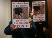 FDNY firefighters hold signs at Monday's City Council meeting