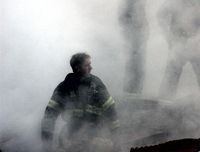 This US Navy photo released 17 September, 2001, shows a firefighter emerging from the smoke and debris of the World Trade Center September 14, 2001.
