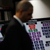 U.S. Attorney General Eric Holder stands in front of chart documenting the structure of alleged crime families during a press conference to announce a large-scale takedown of organized crime.