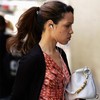 A woman walks down the street listening to an iPod