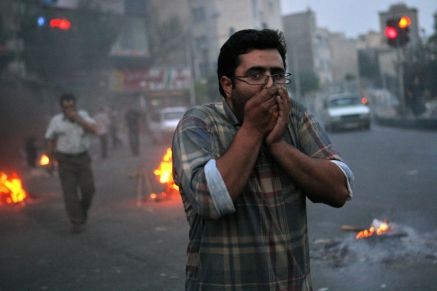 Iranian protesters cover their face from tear gas during clashes with riot police in Tehran on June 20, 2009.
