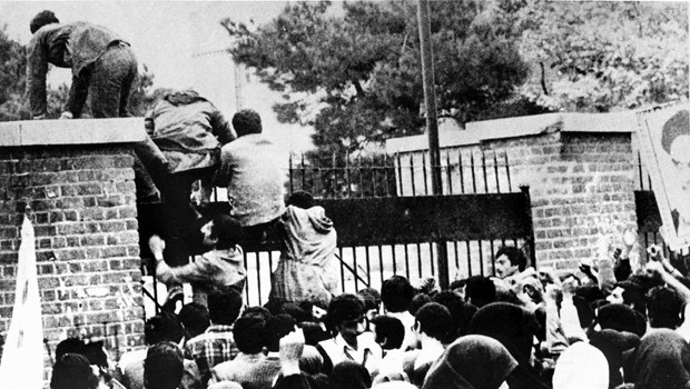 Iranian students climb over the wall of the U.S. embassy in Tehran during the Iranian Revolution, 4th November 1979. The students went on to seize the embassy staff, and hold 52 of them as hostages fo
