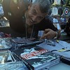 Joe Conzo Jr. at a hip-hop event in Crotona Park; posing with his book of Bronx photos