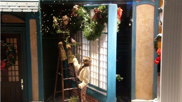 A couple decks the halls in a scene in one of Lord and Taylor's holiday window.