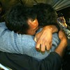 Alfonso Avalos(R) father of Chilean miner Florencio Avalos and Wilson Avalos brother of Florencio embrace each other after Florencio was brought to the surface