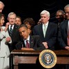 US President Barack Obama signs the Dodd-Frank Wall Street Reform and Consumer Protection Act alongside members of Congress, the administration and US Vice President Joe Biden