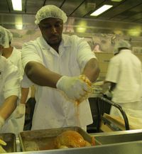 Inmate Nathaniel Harris seasons a turkey before putting it in the oven.