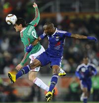 Mexico's striker Guillermo Franco (L) challenges France's defender William Gallas during the 2010 World Cup group A first round football match between Mexico and France on June 17, 2010