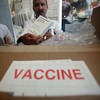 Pharmacy worker Victor Galindez holds nasal spray doses of the H1N1/swine flu vaccine at Montefiore Medical Center October 6, 2009