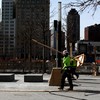 Workers are planting trees and putting in benches at the 9/11 Memorial, World Trade Center,