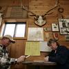 Under mounted antlers and historical photos, Steve and Janet Hren go over their ballots as they vote at the Lazy Doe Saloon in Monarch, Mont., Tuesday, Nov. 7, 2006.
