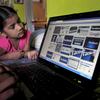 A child looks at a laptop displaying Facebook logos in Hyderabad, India. Friday, May 18, 2012.