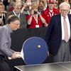 Warren Buffett, chairman and CEO of Berkshire Hathaway, right, watches Bill Gates use an oversize paddle as they play doubles against table tennis prodigy Ariel Hsing in Omaha, Neb.
