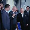 President Dwight D. Eisenhower receives a replica of the Russian Lunik from Premier Nikita Khrushchev during his state visit to the American capital. Vice President Richard Nixon watches.
