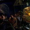 A soldier stands guard next to Tutankhamun's gold funerary mask inside the Egyptian Museum as Egyptian state minister of antiquities Zahi Hawass talks to reporters on February 16, 2011