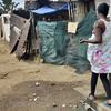 A woman walk in a dusty alley in the impoverished Diepsloot township outside Johannesburg on April 16, 2014. 