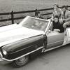 Johnny Cash in the driver's seat of the 'One Piece At a Time' Cadillac with Bruce Fitzpatrick standing at the far right.