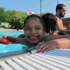 Aura Mejia, 6, is all smiles as she gets ready to swim into the water with her kick board. Mejia said she felt brave as she swam during her lesson at the Roberto Clemente Park pool.