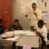 Students at Thurgood Marshall Academy work with an after-school helper to figure out a science project. 