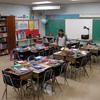 A teacher readying her classroom for the first day of school. 