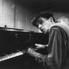 Brilliant Canadian pianist Glenn Gould as a young man, singing as he plays piano at a Steinway warehouse before choosing one for his recording session at Columbia Recording studios.