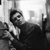 Jack Kerouac leans closer to a radio to hear himself on a broadcast, 1959