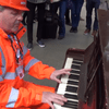A traffic marshal in London's St Pancras Station surprises travelers with a quick turn on a public piano.
